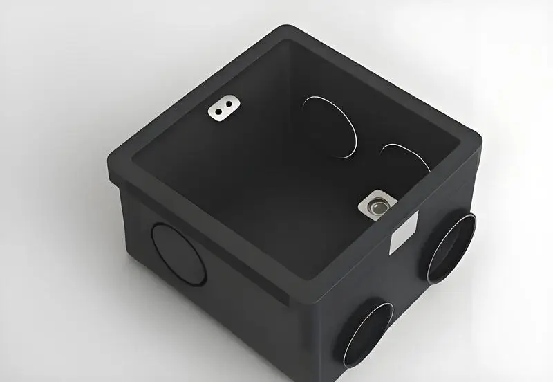 Black insert molded plastic box with circular cutouts on the sides