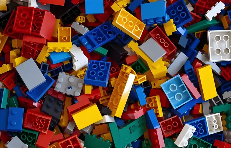 Various colorful Lego injection molding bricks scattered randomly