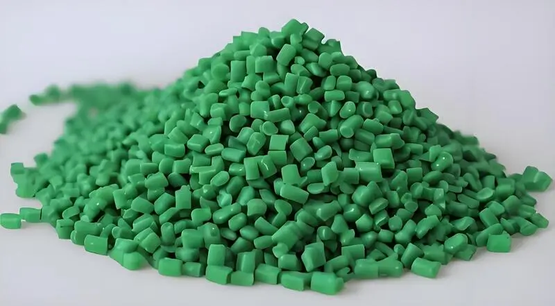 Green injection molding material polycarbonate (PC) pellets on white background.
