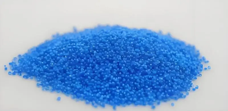 A pile of tiny blue injection molding material Thermoplastic Elastomer (TPE) pellets on a white background