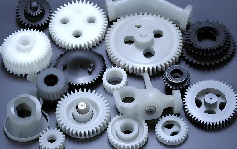 White and black injection molded gears of various sizes and shapes