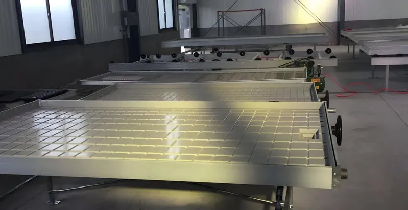 A factory interior with solar panels on assembly line roller tables