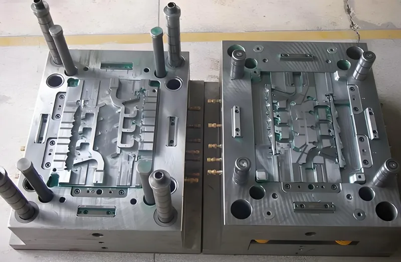 Two metal injection molding dies with complex designs, used in manufacturing processes