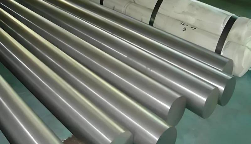 Several polished titanium rods arranged parallel to each other with wrapped bundles in the background
